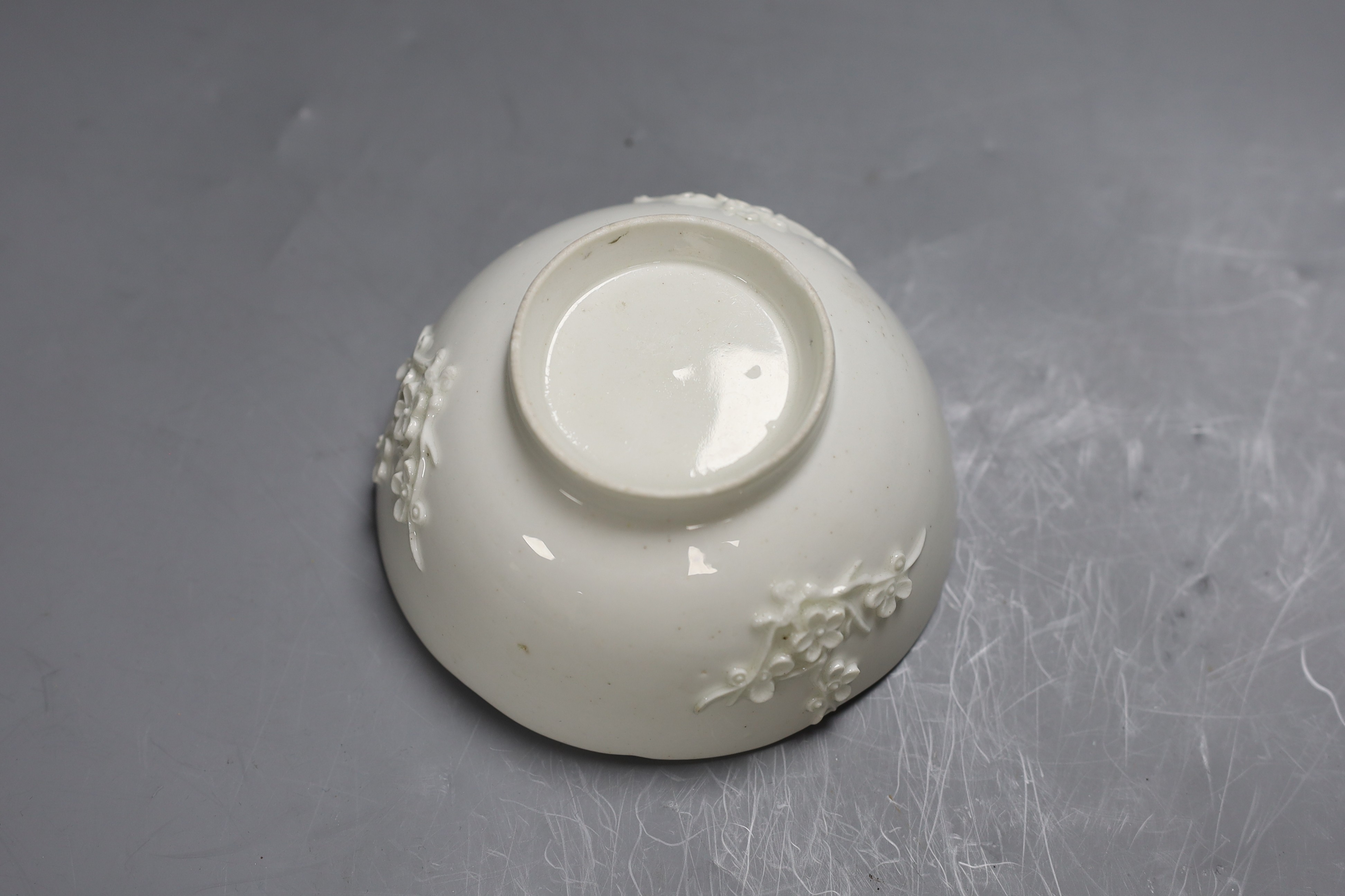 An 18th century Bow white glazed ‘prunus’ bowl, and a Bow octagonal plate, with floral design, 21cm diameter